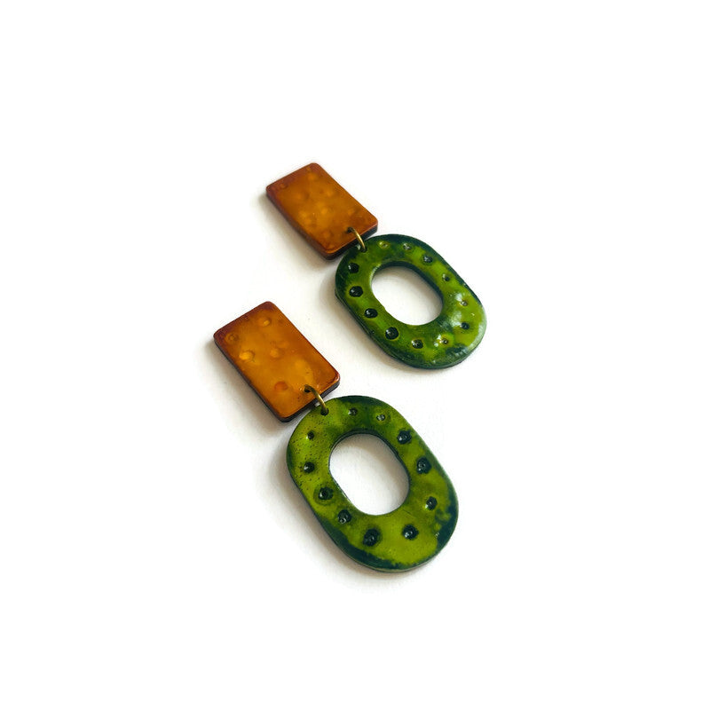 Pair of earrings with green and yellow oval shapes on a white background