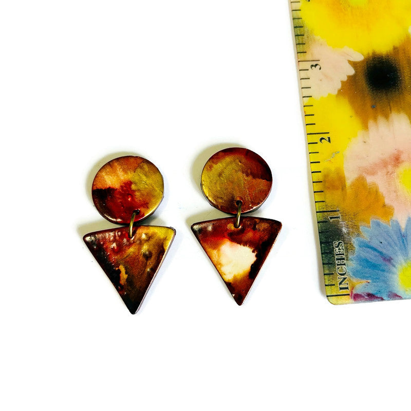 Pair of round and triangle-shaped earrings with a colorful tie-dye ruler for scale.