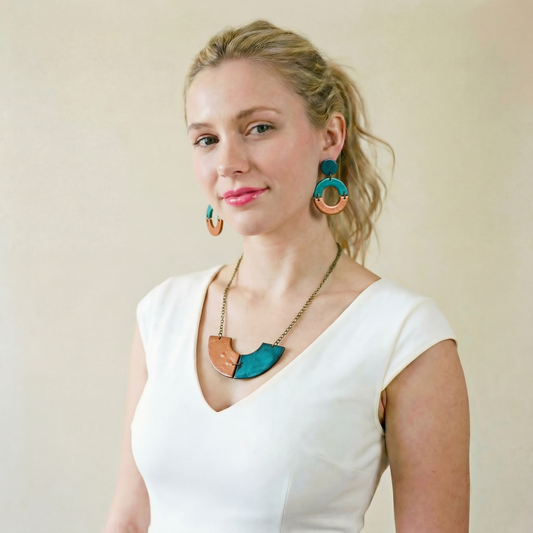 Woman wearing a white top and colorful jewelry against a plain background