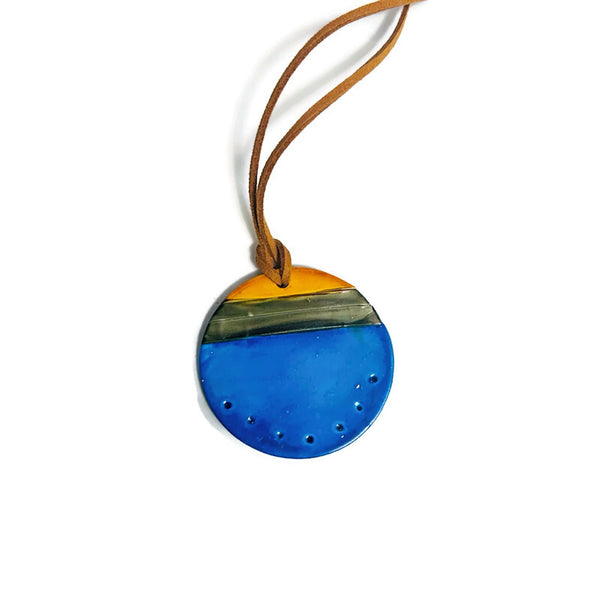 Round blue pendant with a brown cord on a white background