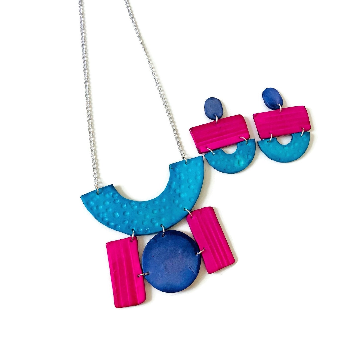 Statement necklace with silver chain and turquoise, denim blue, and pink layered charms