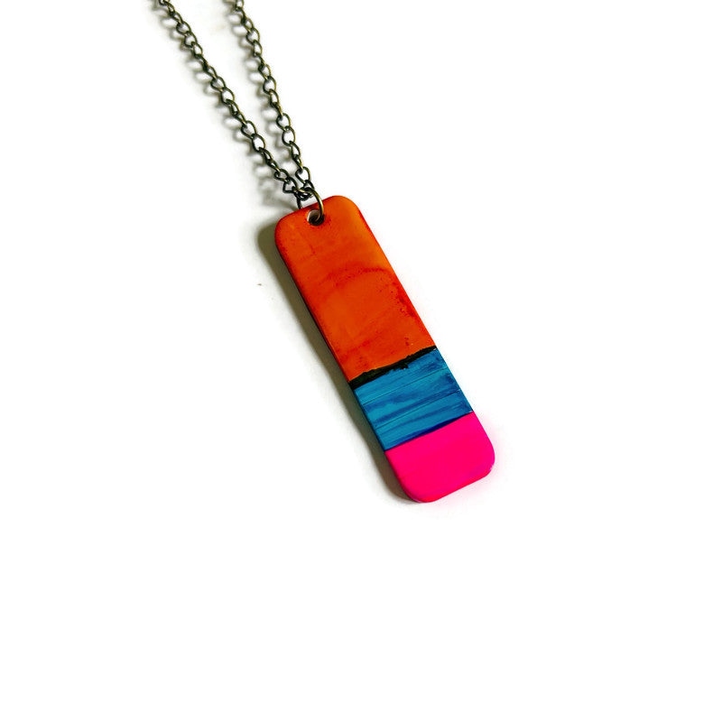 Colorful rectangular pendant on a chain against a white background