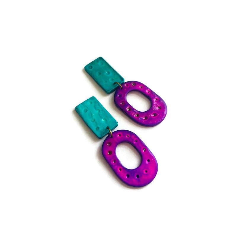 Colorful earrings with turquoise and purple components on a white background