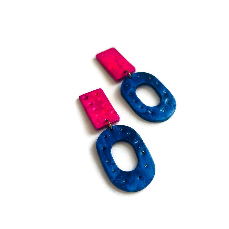 Pair of colorful earrings with pink and blue shapes on a white background