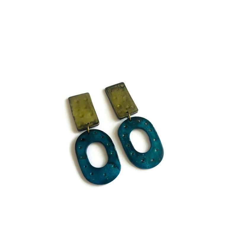 Pair of earrings with grey and blue oval shapes on a white background