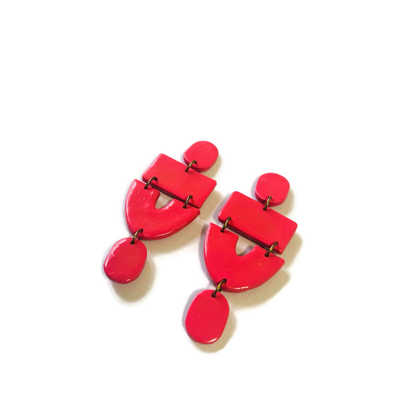 Red clip-on earrings with geometric panels and small dangling teardrops