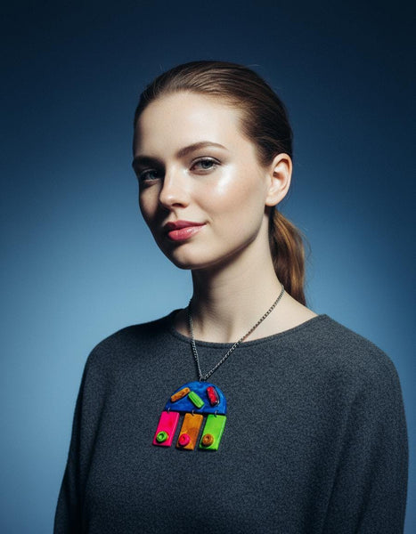 Woman wearing a dark gray sweater with a colorful pendant on a blue background
