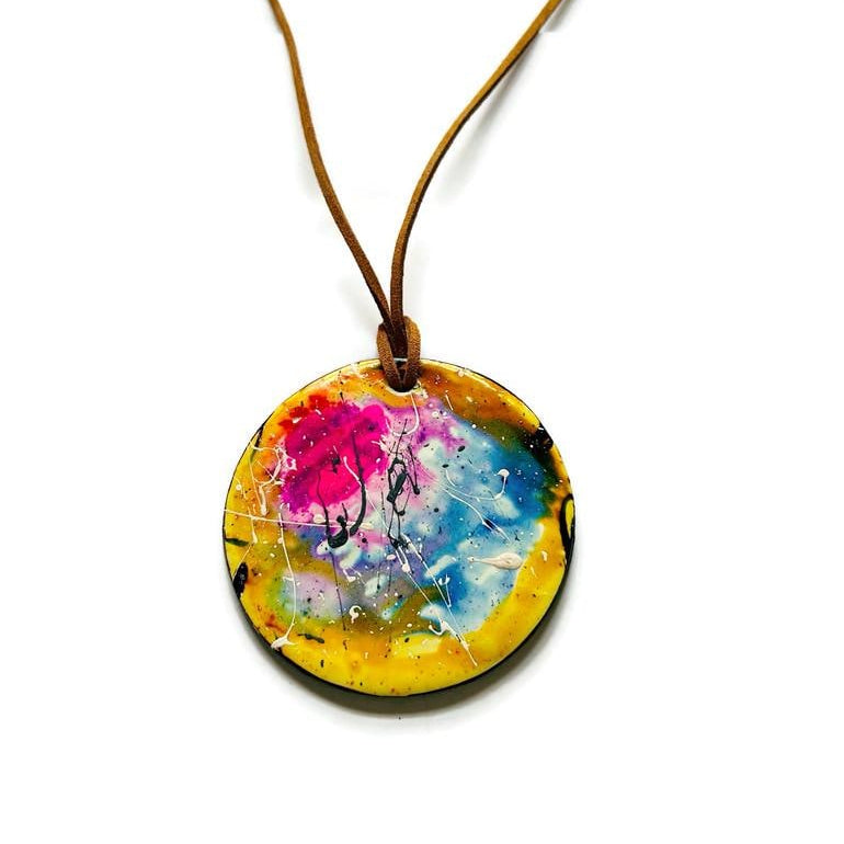 Colorful round pendant on a brown cord against a white background