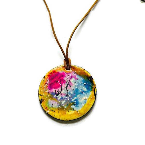 Colorful round pendant on a brown cord against a white background