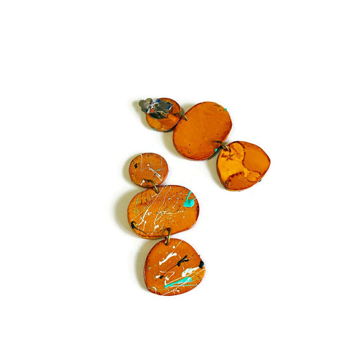 Orange earrings with marbled design on a white background