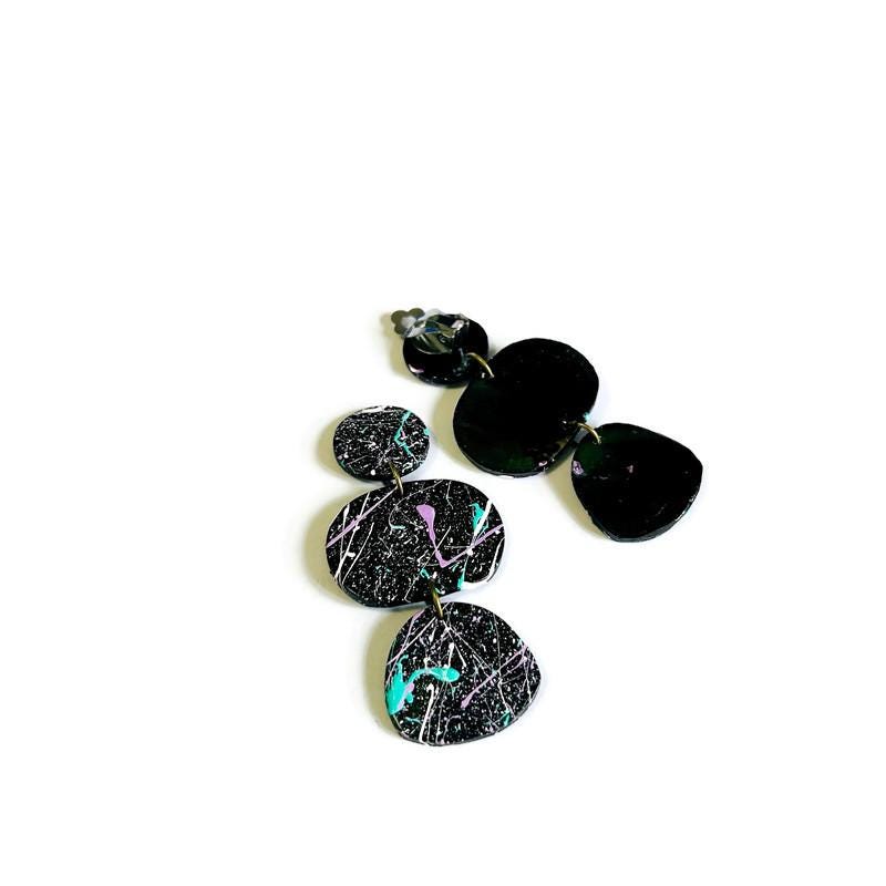 Black and multicolored earrings on a white background