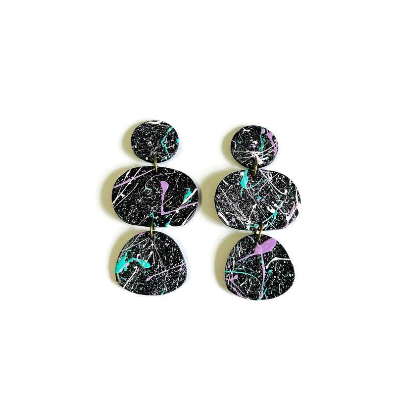 Black and multicolor abstract patterned earrings on a white background