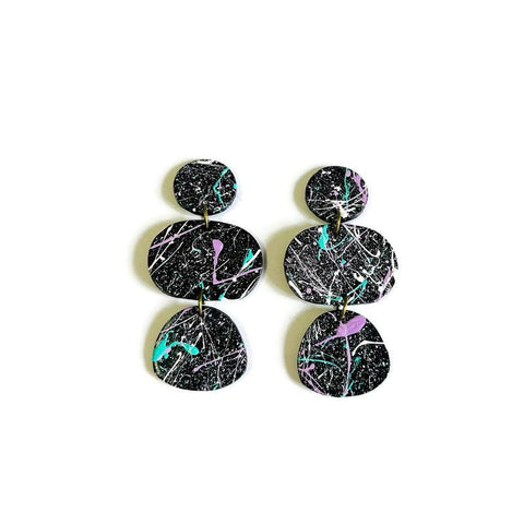 Black and multicolor abstract patterned earrings on a white background