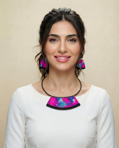 Woman wearing a colorful necklace and earrings against a beige background