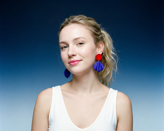 Woman wearing colorful earrings against a gradient blue background