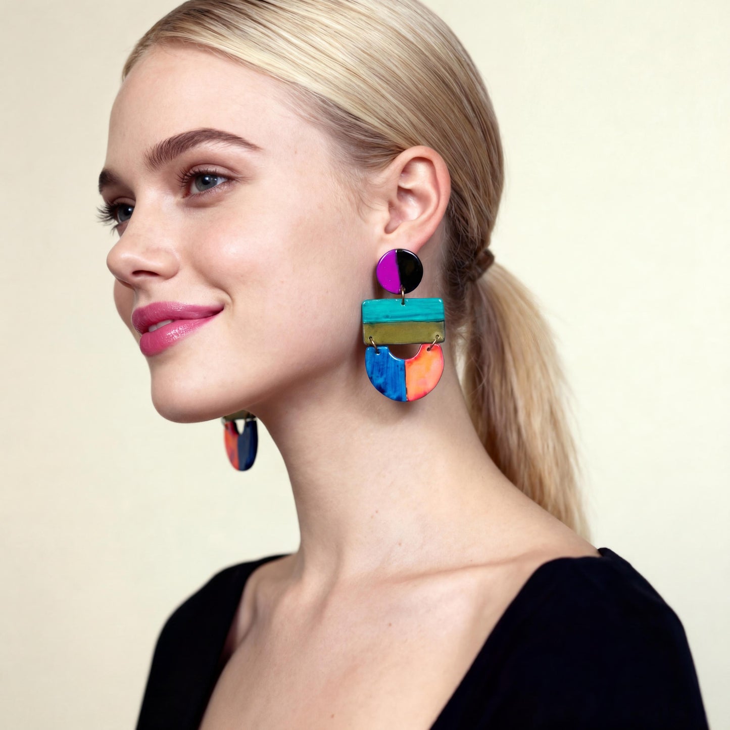 Woman wearing colorful earrings against a neutral background