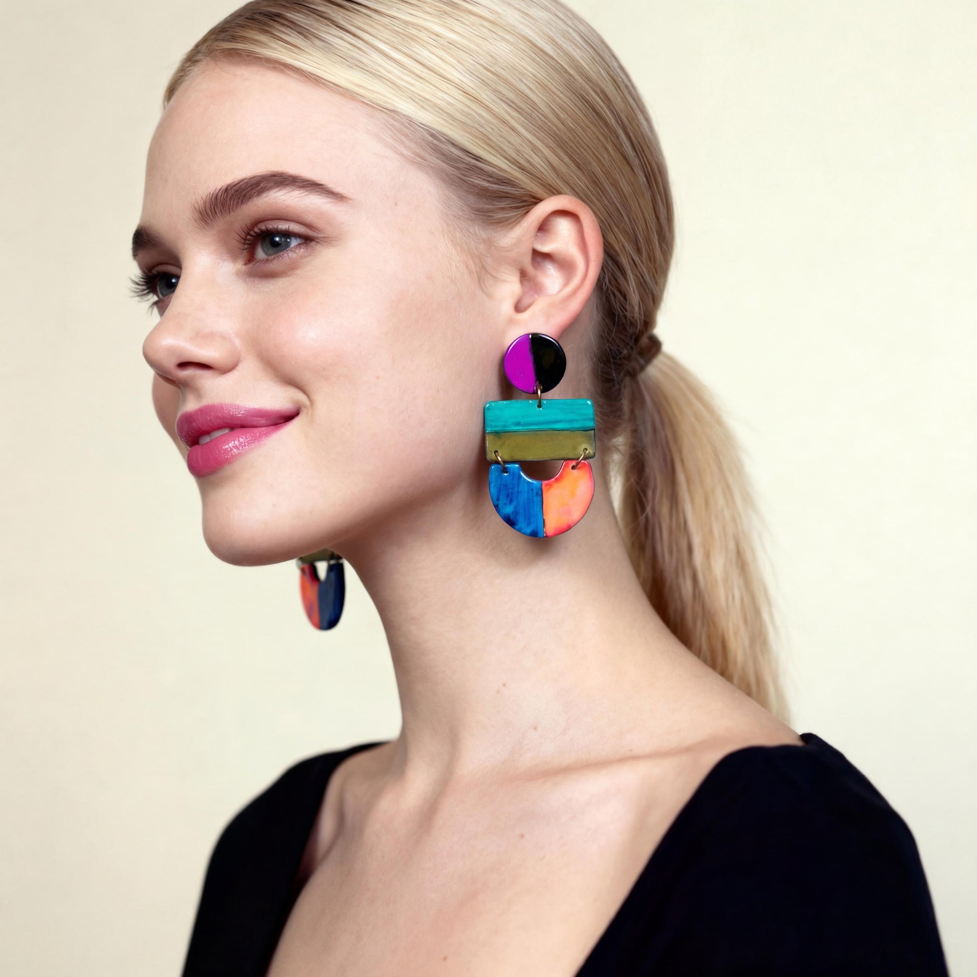 Woman wearing colorful earrings against a neutral background
