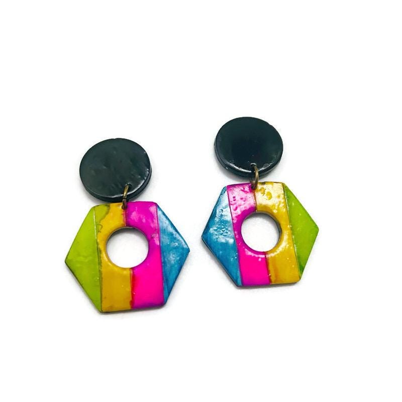 Colorful geometric earrings with black tops on a white background