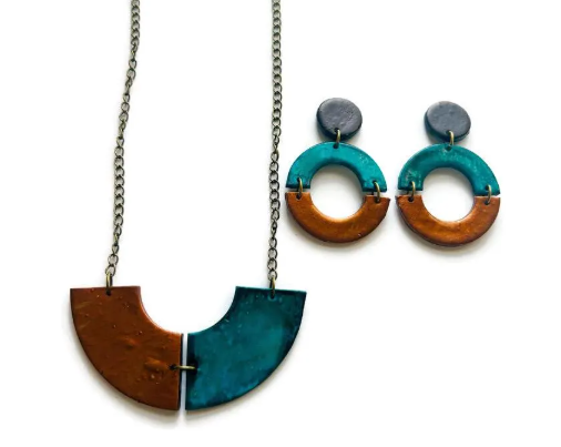 Jewelry set with a necklace and earrings featuring turquoise and brown colors on a white background.