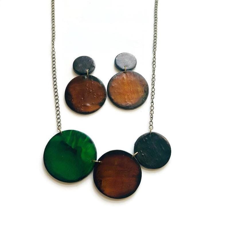 Necklace and earring set with round, multicolored pendants on a white background