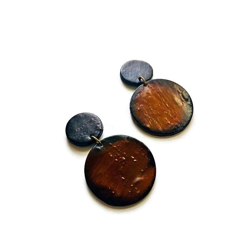 Pair of brown circular earrings on a white background