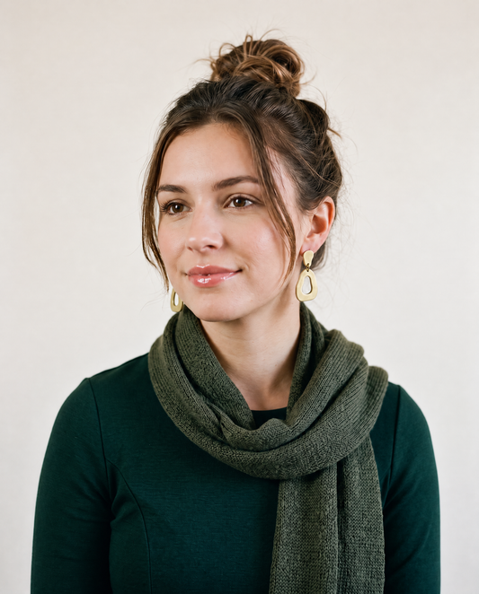 Green organic hoop earrings with teardrop cutout and gold post backs on model