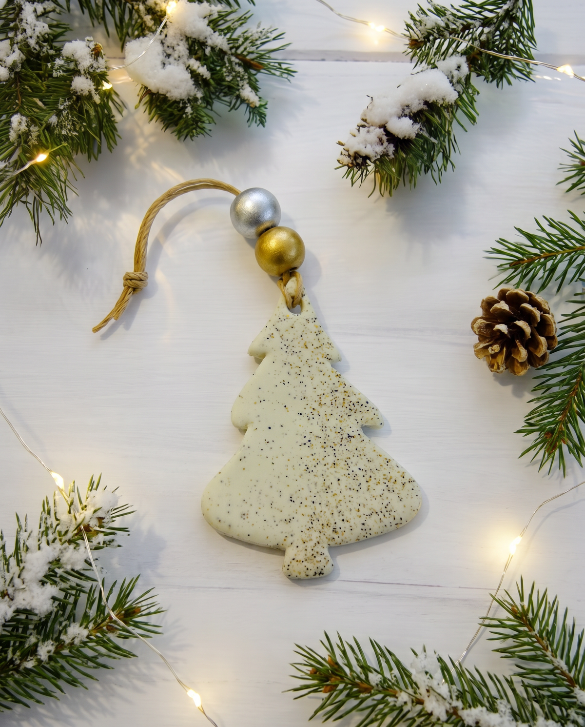 Speckled clay Christmas tree ornament with gold-and-silver top and string loop