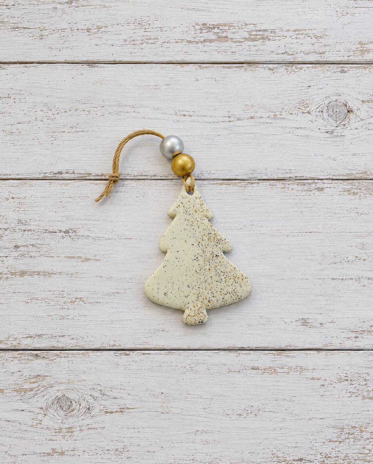 Speckled clay Christmas tree ornament with gold cord and silver-gold cap at top