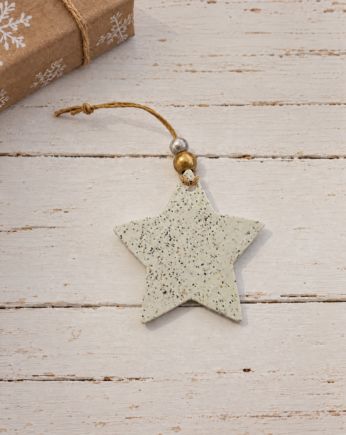 Handmade star Christmas ornament, speckled clay with gold bead loop and hanging cord.