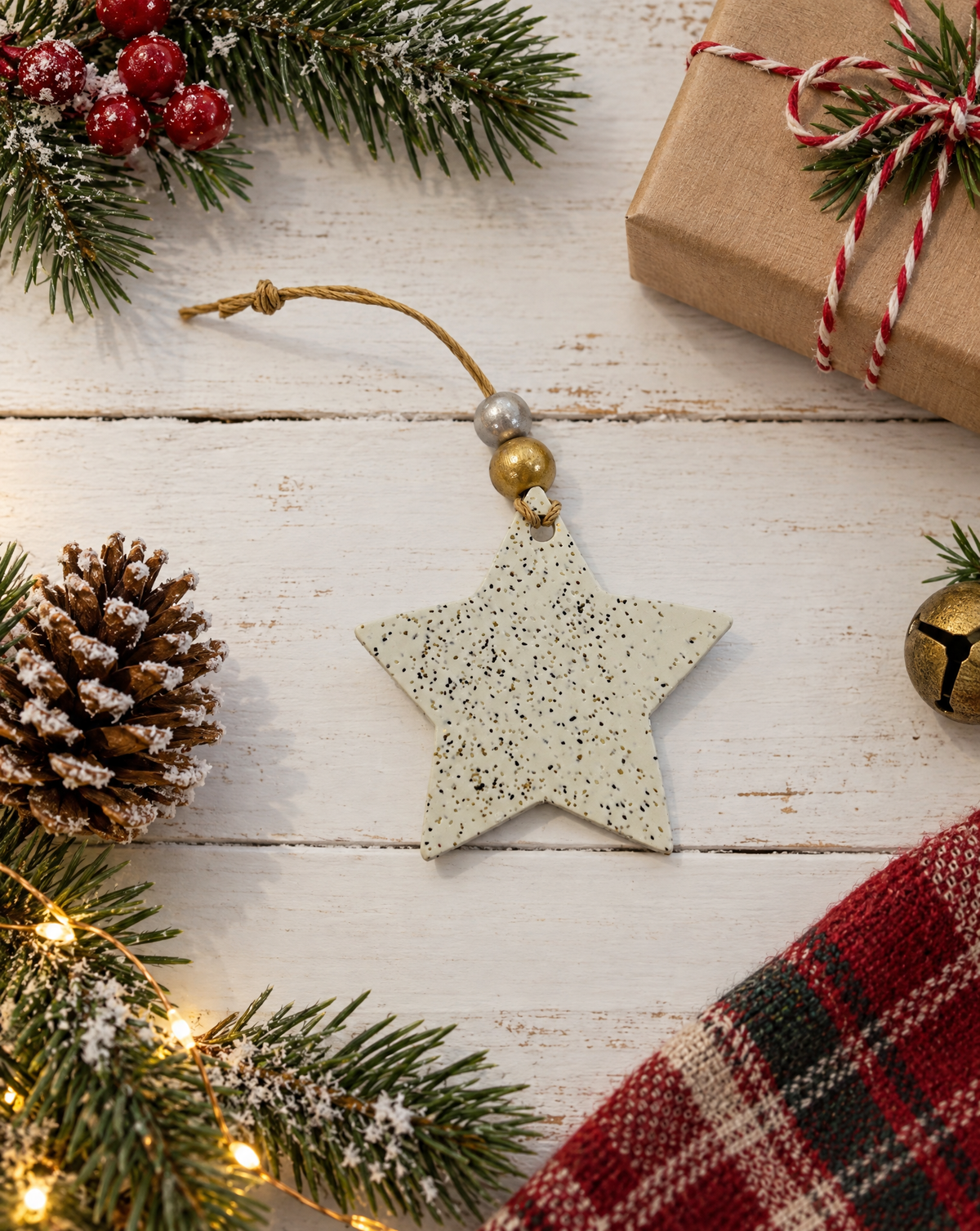 Handmade star Christmas ornament with speckled clay surface and gold bead top loop.