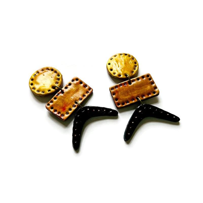 Geometric drop dangle earrings featuring copper rectangles and black curved dangles with yellow tops.
