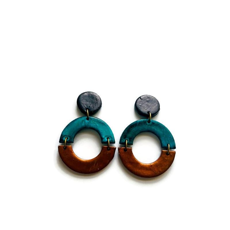 Pair of earrings with teal and brown design on a white background