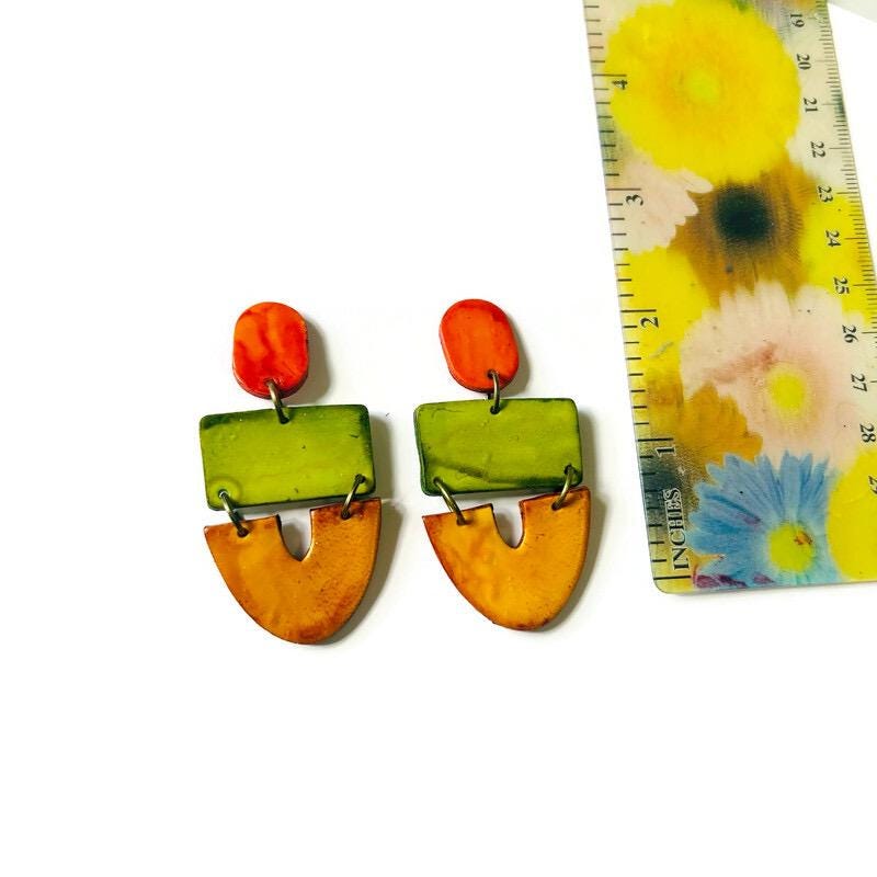 Colorful earrings with a floral-patterned ruler on a white background