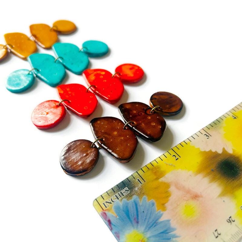 Colorful earrings near a floral ruler for scale.