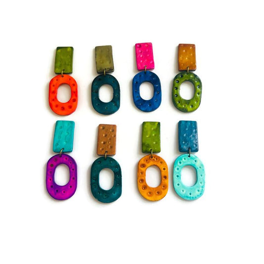 Colorful earrings with geometric designs on a white background