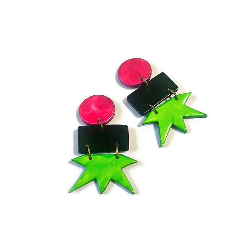 Geometric star drop earrings: bright pink circles, black rectangles, neon green star charms