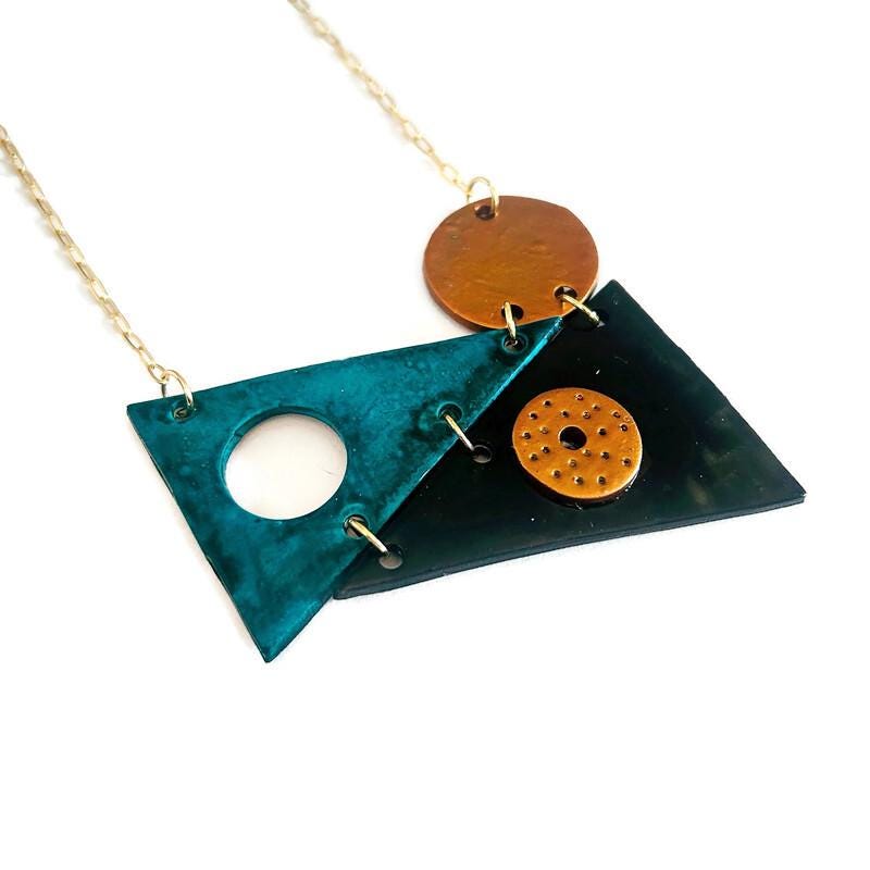Geometric triangle pendant necklace with teal and dark triangles, orange round disc, gold chain