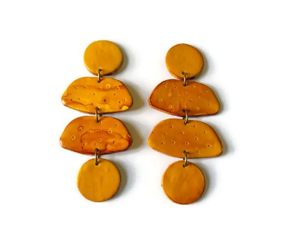 Pair of mustard yellow earrings on a white background