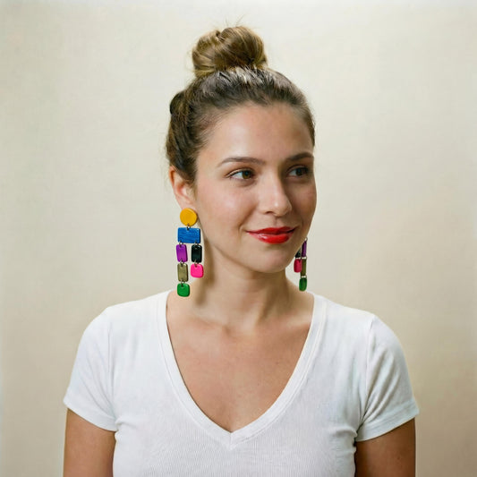 Woman wearing colorful earrings against a plain background