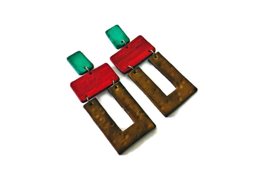 Colorful earrings with red, green, and brown geometric shapes on a white background