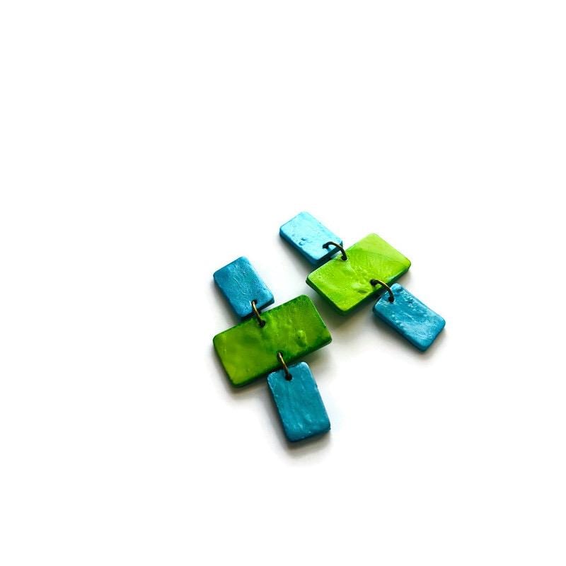 Pair of blue and green earrings on a white background