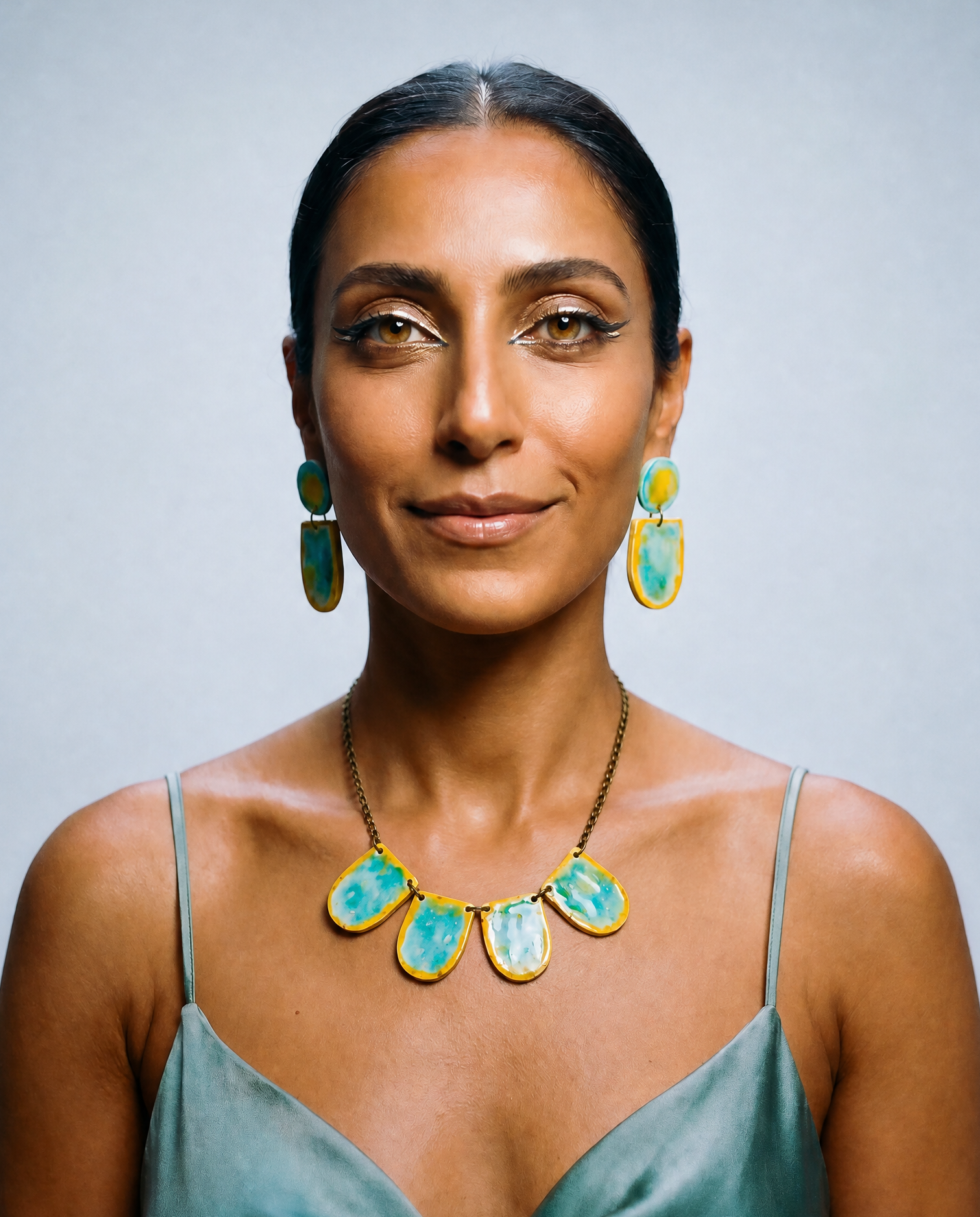 Turquoise and yellow painted drop earrings with matching necklace on a model