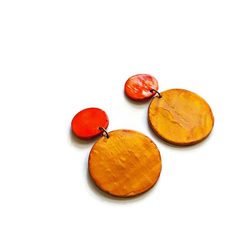 Pair of orange and yellow earrings on a white background