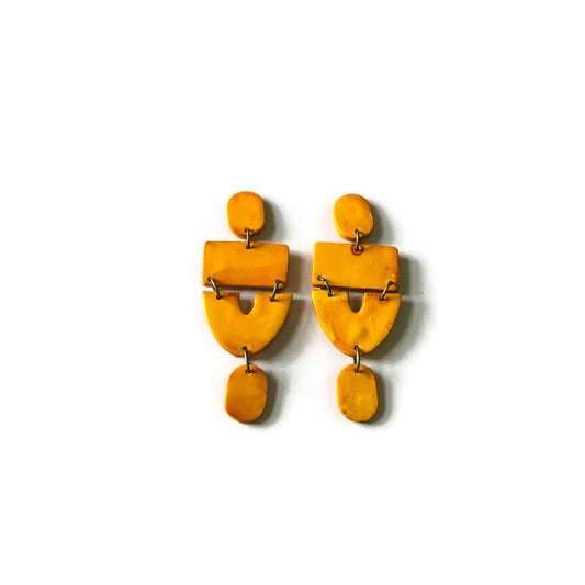 Pair of yellow earrings on a white background