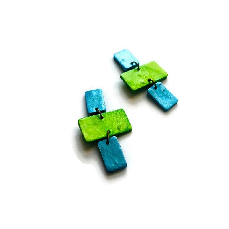 Pair of green and blue square-shaped earrings on a white background