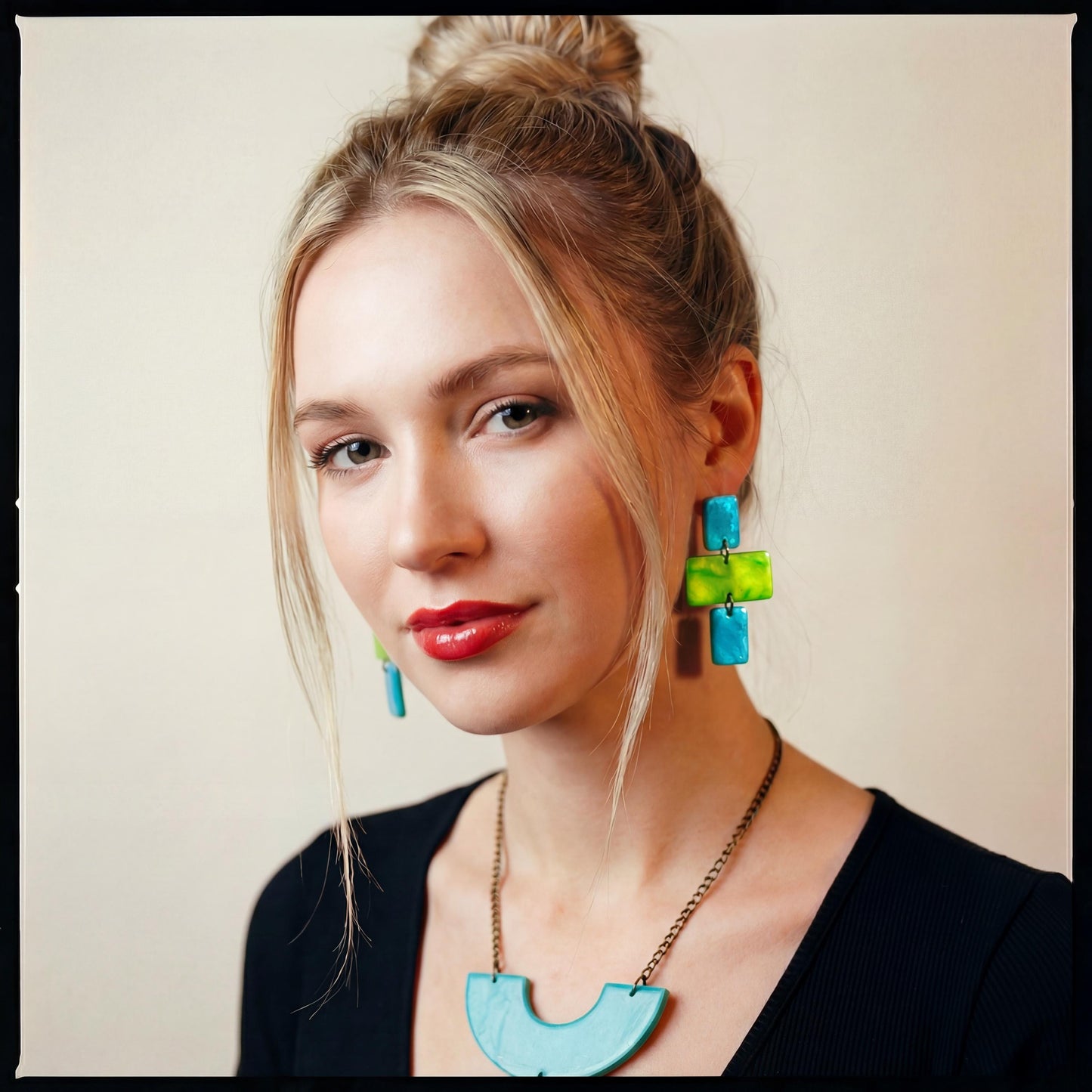 Woman wearing colorful earrings with a plain background