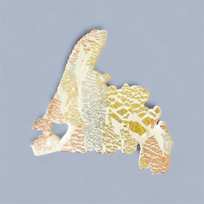 PEI fridge magnet in white, gold, and orange speckled clay with mixed foil flakes