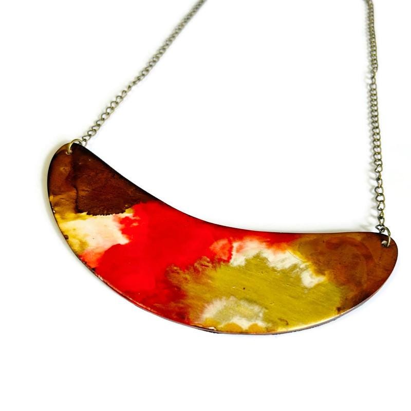 Colorful semi-circular pendant on a chain against a white background