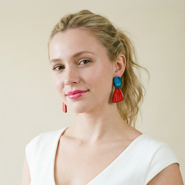 Woman wearing colorful earrings against a plain background