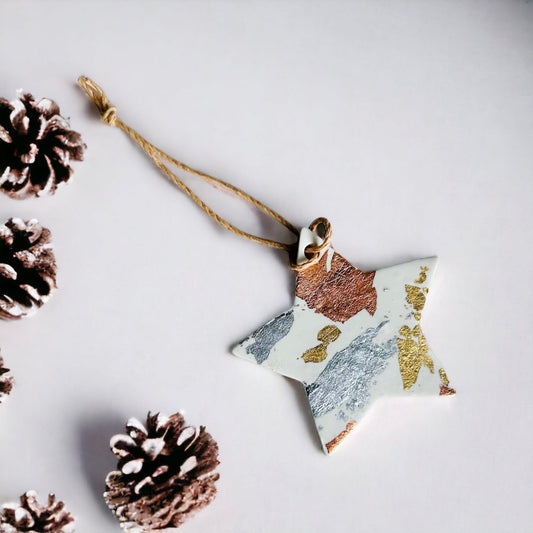 Hanging white star Christmas ornament with gold and copper foil flecks on gold cord